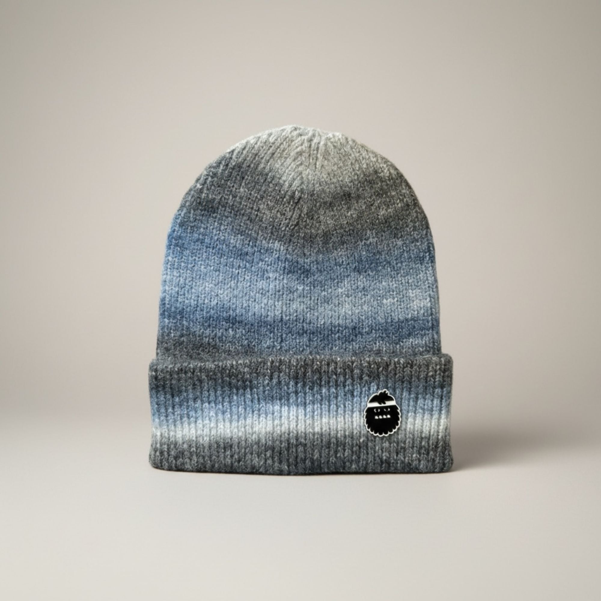 Gradient beanie with a bigfoot logo on a neutral background