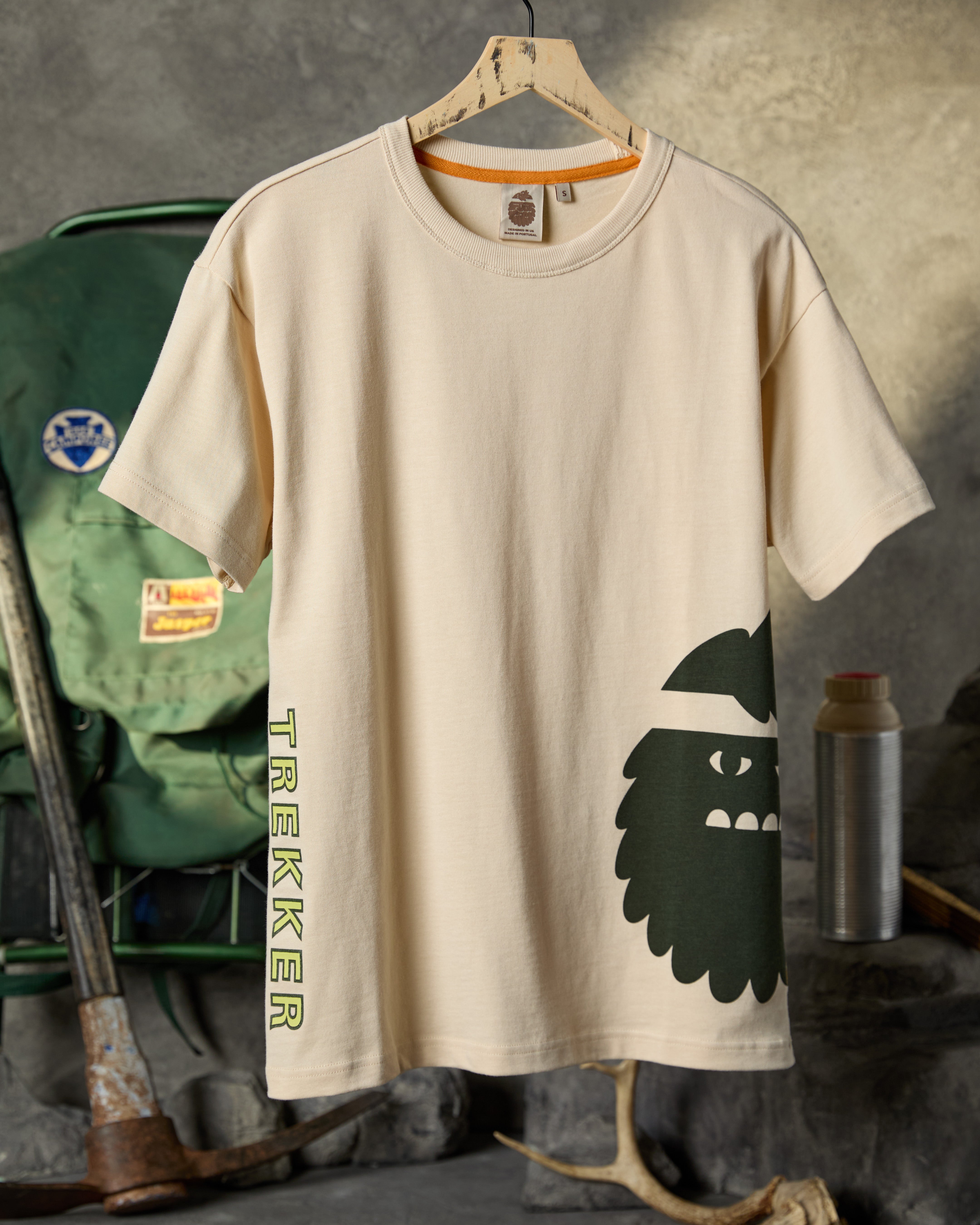 Bigfoot Kick Trekker T-Shirt hanging with wilderness gear behind it